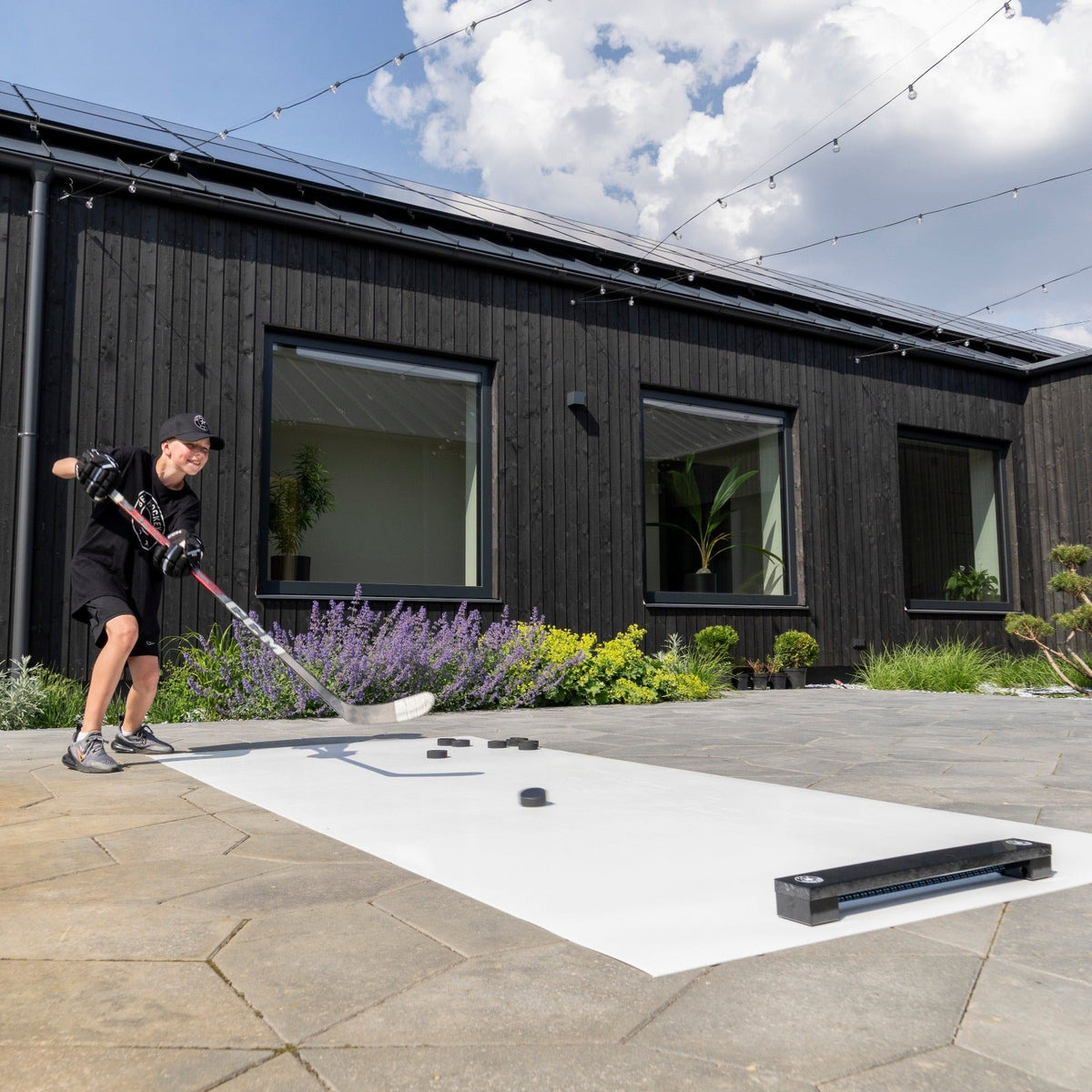 Hockey player practicing passing accuracy with the Extreme Hockey Rebounder in a backyard