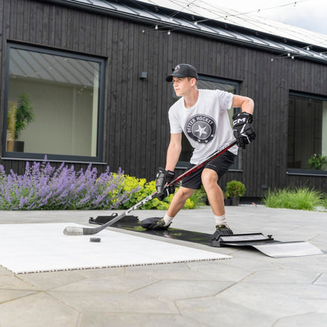 Hockey player in full extension on a slide board training on a garden patio, Better Hockey gear