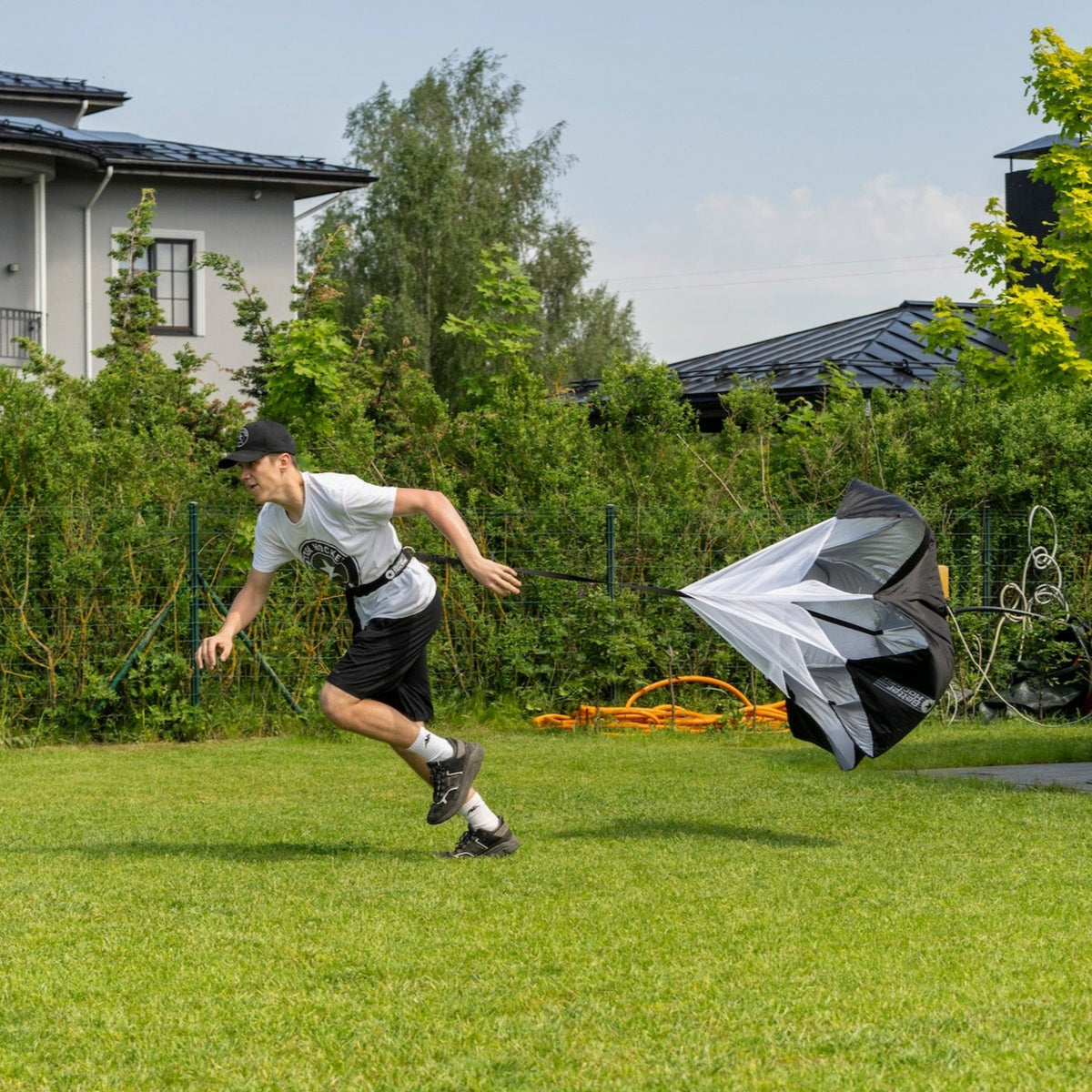 Hockey player sprinting with speed chute outdoors building explosive speed and agility
