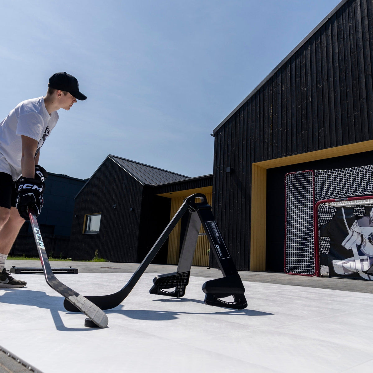 Hockey player practicing defensive stick positioning with the Pro Defender trainer on an outdoor training surface
